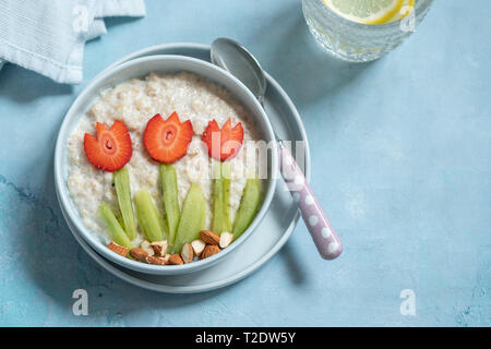 Lustige Schüsseln mit Haferflocken Porridge mit Frühling Blumen Stockfoto