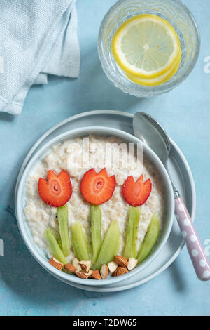 Lustige Schüsseln mit Haferflocken Porridge mit Frühling Blumen Stockfoto