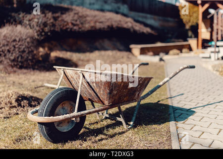 Leeren alten rostigen Garten Schubkarre im Frühling Stockfoto