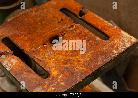 Ein Bügeleisen Platte mit Bohrungen abgedeckt mit einer dicken Schicht von Rost, Metall isst Stockfoto