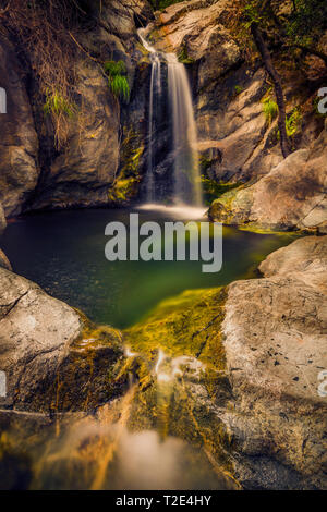 Kleinen und schönen Wasserfall bilden eine tiefe Bohrung durch Klippen auf Samothraki Insel in Griechenland in einer schönen Landschaft umgeben Stockfoto