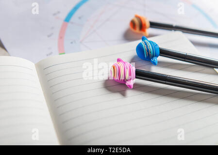 Offenen Notebooks für das Schreiben von Ideen und astrologische Geburt Geburtshoroskop Festlegung auf grauem Hintergrund. Kaffee und Planeten Stifte in der Nähe. Ansicht von oben. Idee der Astrol Stockfoto