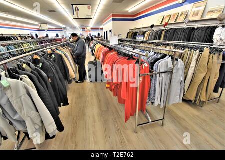 Shoping für gebrauchte Kleidung für Familie an Second hand Store in Amerika für die Wiederverwendung Stockfoto