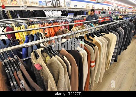 Shoping für gebrauchte Kleidung für Familie an Second hand Store in Amerika für die Wiederverwendung Stockfoto