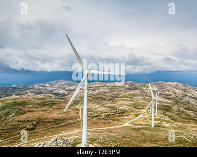 Detaillierte Luftaufnahme von Drohne, eine Windkraftanlagen auf Berge, dramatische Himmel als Hintergrund, in Portugal Stockfoto