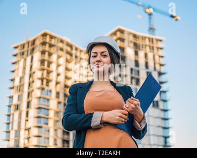 Wunderschöne Business woman Ingenieur steht mit plan Papiere. Stockfoto