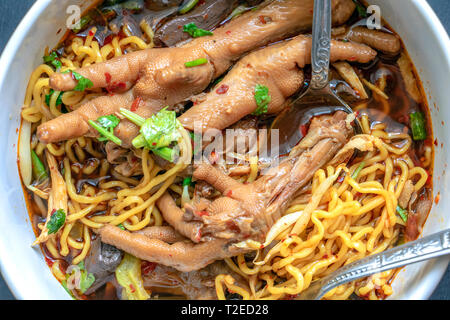 Geschmorte Hühnersuppe mit bitteren Kürbis Nudel. Huhn Kürbis Nudeln mit Huhn Bein, Thai Food. Chicken Claw mit würziger Suppe. Stockfoto
