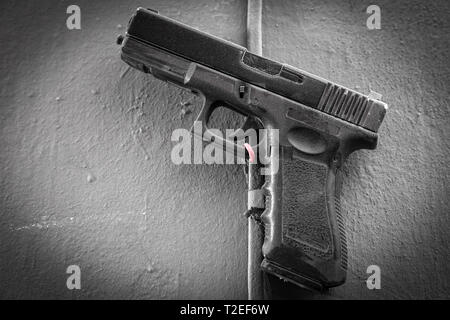 Close-up Kunststoff Spielzeugpistole aus Kunststoff mit einer Gabel an der alten Mauer befestigt Stockfoto