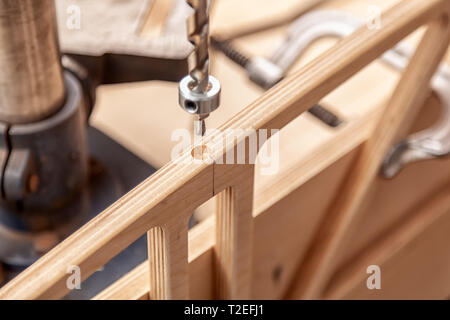 Nahaufnahme von einem Mann mit Arbeitskleidung und ein Tischler hat ist das Schnitzen einer Holzplatte auf einem großen Bohrmaschine in einem Workshop Stockfoto