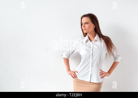 Reife Frau, die isoliert auf die weiße Wand posieren beiseite schaut zuversichtlich Stockfoto