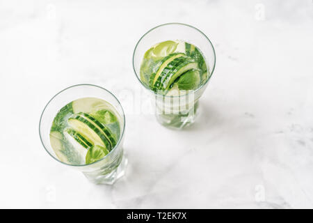 Blick von oben auf die zwei Gläser mit detox infundiert Wasser mit Gurke und Basilikum Stockfoto