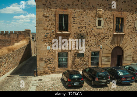 Fassade des alten Gebäudes vor kleinen Platz mit parkenden Autos in Caceres. Eine charmante Stadt mit einem vollständig erhaltenen Altstadt in Spanien. Stockfoto