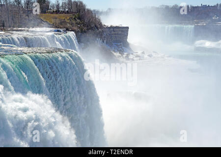 Aussicht auf die Amerikanischen Wasserfälle in Niagara Falls im Winter mit gefrorenem Eis und Schnee in der Niagara River Stockfoto