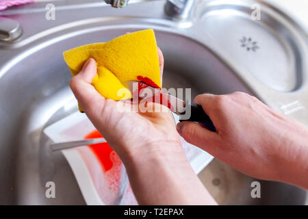 Eine Frau schneidet sich mit einem Messer in der Küche Stockfoto