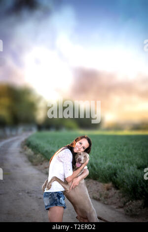 Weimaraner hound junge Frau, die eine Umarmung Stockfoto