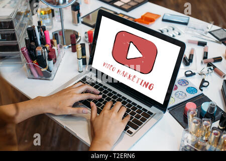 Erntegut Hände von Frau mit Laptop mit Make-up-Kits am Tisch - Video Marketing und moderne digitale Content Marketing Strategie Konzept Stockfoto