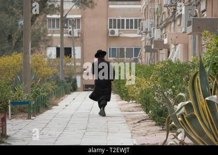 Eine ultra-orthodoxe Juden wandern in Shechunat Yeelim (die Ibex-Nachbarschaft) in Arad, einer Stadt im südlichen Bezirk von Israel. Gur Chassidim und säkularen Juden in Arad haben seit Jahren auf Kriegsfuß. Weltliche Bewohner werfen Gur Chassidim zu versuchen, über die Stadt und ihre Lebensweise Schaden, während die lokalen Gur Bevölkerung ringen, daß die Stadt sich weigert, mit dem die kommunalen Dienstleistungen zur Verfügung zu stellen. Stockfoto