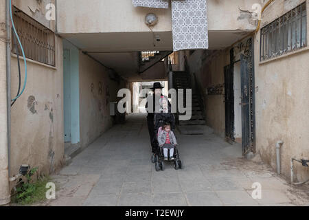 Eine ultra-orthodoxe Juden wandern in Shechunat Yeelim (die Ibex-Nachbarschaft) in Arad, einer Stadt im südlichen Bezirk von Israel. Gur Chassidim und säkularen Juden in Arad haben seit Jahren auf Kriegsfuß. Weltliche Bewohner werfen Gur Chassidim zu versuchen, über die Stadt und ihre Lebensweise Schaden, während die lokalen Gur Bevölkerung ringen, daß die Stadt sich weigert, mit dem die kommunalen Dienstleistungen zur Verfügung zu stellen. Stockfoto