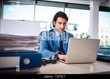 Verkettete männliche Angestellte mit übermäßiger Arbeit unzufrieden Stockfoto