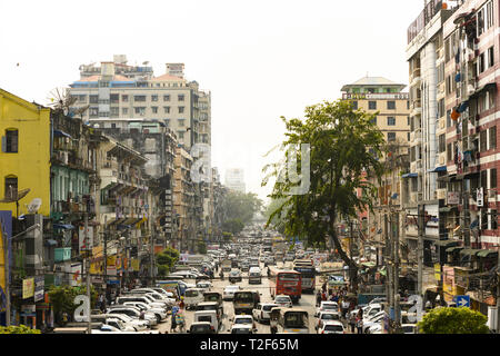 Täglichen Verkehr und das Leben in der Stadt auf den geschäftigen Straßen von Yangon während des Sonnenuntergangs. Yangon ist die Hauptstadt der Region Yangon Stockfoto