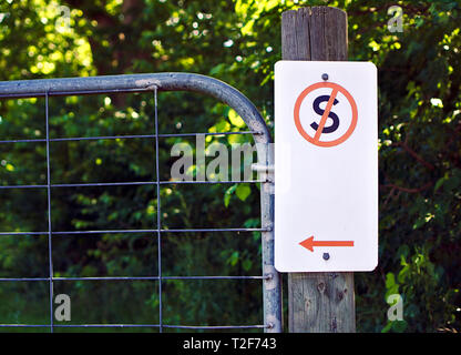 Nahaufnahme der Keine stehende Zeichen in Rot, Schwarz und Weiß auf hölzernen Pfosten und Metall Tor auf der linken Seite Stockfoto