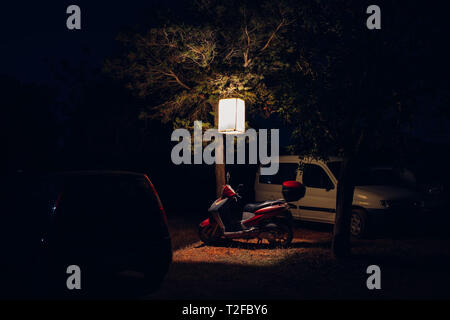 Moped Motorrad unter der Laterne geparkt in Ibiza bei Nacht Stockfoto