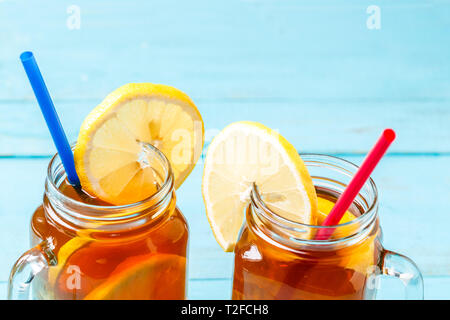 Eistee in einem Glas mit Zitrone auf Blau Holz- Hintergrund. Stockfoto