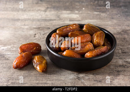 Termine in schwarz Schüssel auf hölzernen Tisch Stockfoto