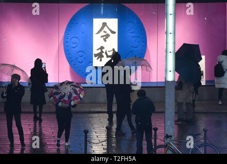 Tokio, Japan. 1 Apr, 2019. Reiwa wird der Name für die nächste Ära der Japan. Die Periode wird voraussichtlich am 1. Mai 2019 zu starten. Auf dem Foto die Kanji Zeichen für reiwa als Menschen vergeht im Bezirk Ginza in Tokio Japan gesehen werden können. April 1, 2019. Foto: Ramiro Agustin Vargas Tabares Credit: Ramiro Agustin Vargas Tabares/ZUMA Draht/Alamy leben Nachrichten Stockfoto