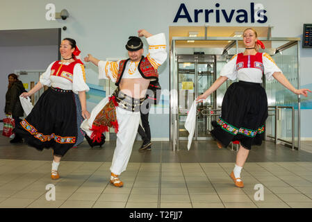 Ryanair hat ihre erste von London Luton Flughafen mit slowakischen Tänzer Gruß die erste Ankunft Passagiere im Terminal gestartet Stockfoto