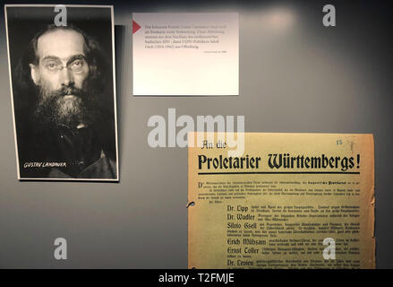 Karlsruhe, Deutschland. 02 Apr, 2019. In der Ausstellung 'Die Ermordung von Gustav Landauer" (die Ermordung von Gustav Landauer) ist in der Allgemeinen staatlichen Archiv Karlsruhe, eine Vitrine neben einem portraitfoto von Gustav Landauer zeigt eine Bekanntmachung aus dem Jahr 1919, in dem die SPD-geführte Regierung von Württemberg gegen die Münchner Räterepublik spricht. 100 Jahre nach der Ermordung der revolutionären Gustav Landauer, Kürzlich gefunden Gericht Dateien der allgemeinen staatlichen Archiv Karlsruhe ein neuer Blick auf die Kriminalität. Quelle: Christopher Hirsch/dpa/Alamy leben Nachrichten Stockfoto