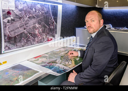 Ballyhalbert, County Down, Nordirland, Irland. 02 Apr, 2019. Detective Betriebsleiter Jason Murphy in der Leitwarte mit historischen Karten der Gegend. Er und die dorrian Familie gefällt für Informationen über die Wherabouts von Lisa Dorrian, die verloren gingen im Jahr 2005 nach einer Partei in einem Caravan Park. Sie haben ein WW2 Flugplatz neben dem Park mit neuer Technologie, einschließlich Ground Penetrating Radar, sucht der unterirdischen Hohlräume zu leiten revisited, und wird auf den Caravan Park mit diesem zu suchen. Credit: Stephen Barnes/Alamy leben Nachrichten Stockfoto