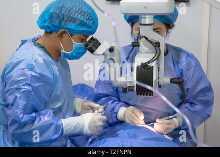 (190402) - PHNOM PENH, 2. April 2019 (Xinhua) - Arzt Liang Hao (R) des ersten angeschlossenen Krankenhaus von Guangxi Medizinische Universität führt eine Staroperation für Summe Meyle am Krankenhaus in der Provinz Kampong Cham Kampong Cham, Kambodscha, 15. März 2019. Summe Meyle, 36, ist alleinerziehende Mutter mit 5 Kindern. Um zu helfen, ihre finanziellen Bedingungen, zwei von meyle's Töchter jetzt Arbeiten in der Hauptstadt Phnom Penh, während zwei ihrer Söhne leben in einem Pflegeheim zu verbessern. Meyle lebt jetzt in einem gemieteten shanty Haus mit ihrer jüngsten Tochter. Meyle von katarakt nach Ihrem erlitten Stockfoto