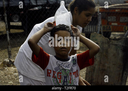 Los Guayos, Carabobo, Venezuela. 2 Apr, 2019. April 02, 2019 Kinder beteiligen sich an der Suche nach Wasser, Laden und Übertragen von Containern aus dem heimlichen Outlet in ihre Häuser, die mehr als 14 Tage ohne die lebenswichtige Flüssigkeit in ihre Häuser nehmen. foto: Juan Carlos Hernandez Credit: Juan Carlos Hernandez/ZUMA Draht/Alamy leben Nachrichten Stockfoto