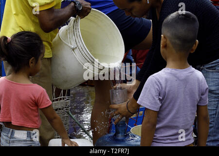 Los Guayos, Carabobo, Venezuela. 2 Apr, 2019. April 02, 2019 Kinder beteiligen sich an der Suche nach Wasser, Laden und Übertragen von Containern aus dem heimlichen Outlet in ihre Häuser, die mehr als 14 Tage ohne die lebenswichtige Flüssigkeit in ihre Häuser nehmen. foto: Juan Carlos Hernandez Credit: Juan Carlos Hernandez/ZUMA Draht/Alamy leben Nachrichten Stockfoto