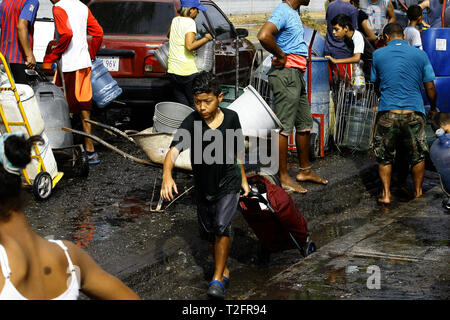 Los Guayos, Carabobo, Venezuela. 2 Apr, 2019. April 02, 2019 Kinder beteiligen sich an der Suche nach Wasser, Laden und Übertragen von Containern aus dem heimlichen Outlet in ihre Häuser, die mehr als 14 Tage ohne die lebenswichtige Flüssigkeit in ihre Häuser nehmen. foto: Juan Carlos Hernandez Credit: Juan Carlos Hernandez/ZUMA Draht/Alamy leben Nachrichten Stockfoto