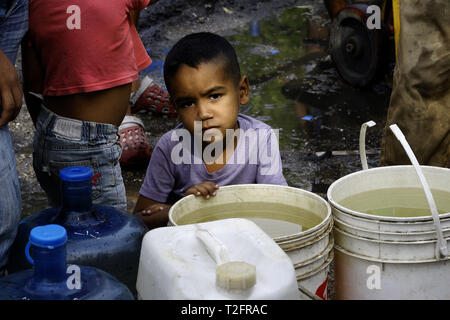 Los Guayos, Carabobo, Venezuela. 2 Apr, 2019. April 02, 2019 Kinder beteiligen sich an der Suche nach Wasser, Laden und Übertragen von Containern aus dem heimlichen Outlet in ihre Häuser, die mehr als 14 Tage ohne die lebenswichtige Flüssigkeit in ihre Häuser nehmen. foto: Juan Carlos Hernandez Credit: Juan Carlos Hernandez/ZUMA Draht/Alamy leben Nachrichten Stockfoto