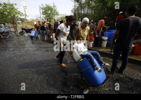 Los Guayos, Carabobo, Venezuela. 2 Apr, 2019. April 02, 2019 Kinder beteiligen sich an der Suche nach Wasser, Laden und Übertragen von Containern aus dem heimlichen Outlet in ihre Häuser, die mehr als 14 Tage ohne die lebenswichtige Flüssigkeit in ihre Häuser nehmen. foto: Juan Carlos Hernandez Credit: Juan Carlos Hernandez/ZUMA Draht/Alamy leben Nachrichten Stockfoto