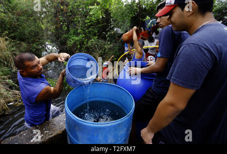 Los Guayos, Carabobo, Venezuela. 2 Apr, 2019. Die Bewohner der Gemeinde Los Guayos aufladen Behälter mit Wasser aus einem heimlichen Outlet in der Branche, und aufgrund der langen Stromausfall im Land ist nicht das Pumpen von Wasser in die Häuser. Bewohner an, dass Sie nicht die lebenswichtige Flüssigkeit in ihren Wohnungen für mehr als 15 Tage erhalten haben. Situation, die in vielen Städten Venezuelas Credit: Juan Carlos Hernandez/ZUMA Draht/Alamy Leben Nachrichten wiederholt wird Stockfoto