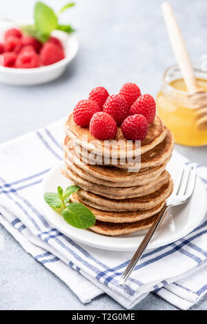 Ganze Weizen Pfannkuchen mit Himbeeren und Honig auf den Tisch. Detailansicht Stockfoto