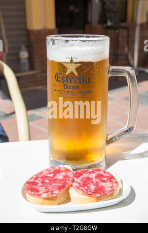 Ein kaltes Bier Estrella Damm Pilsner Bier in einer Tapas Bar in Fuengirola, Costa del Sol, Spanien. Stockfoto