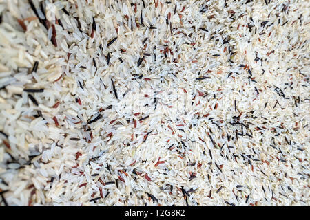 Nahaufnahme, frische organische eine Mischung aus vier Arten von Reis: Weiß, Braun und Langkornreis auf frische Markt, Hintergrund. Reis mix Textur. Stockfoto