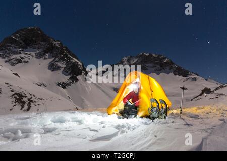 Schneeschuhwanderer in einem beleuchteten Zelt im Schnee auf der Madelejoch, Nachtaufnahme, in der Nähe der Kemptner Hutte, Allgäuer Alpen, Tirol, Österreich Stockfoto