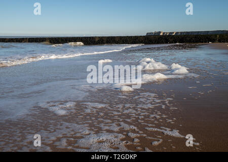 Schaumige weiße Naht Schaum waschen am Strand in der Abendsonne, in Cranbrook, Kent Stockfoto