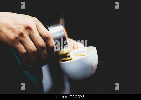 Barista in einem Café arbeitet, in der Nähe von barista Pressen gemahlenen Kaffee mit Sabotage, Barista, Kaffee Portafilter Konzept Stockfoto