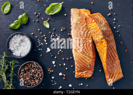 Gebackenes Lachsfilet mit aromatischen Kräutern, Gewürze auf einem Schiefer Platte, Ansicht von oben, flatlay Stockfoto