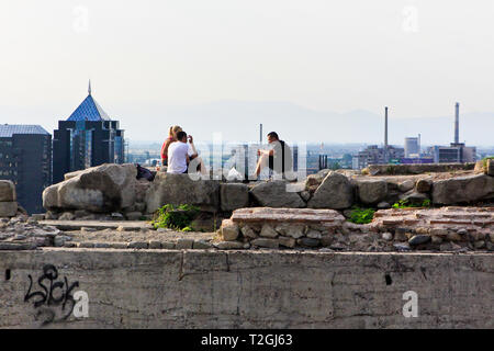 Junge Leute sitzen auf einer Ruine auf dem Hügel Nebet Tepe mit Blick auf die Stadt Plovdiv, Bulgarien Stockfoto