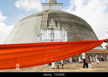 ANURADHAPURA, SRI LANKA - 21 Feb 2016: eine Prozession von Menschen in Weiß gekleidet wickelt eine 366 Meter lange orange Tuch um den Ruwanwelisaya stupa für Stockfoto