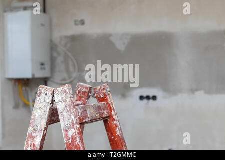 Bild eines unfertigen Wohnung, Leiter, Betonwände - neues Haus in Bau Stockfoto