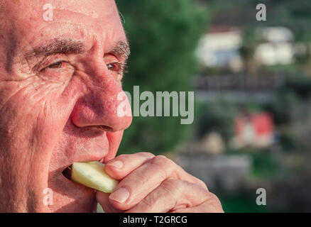 Close-up Portrait eines älteren von 70-79 Jahren apple Essen im Freien, gesunden Lebensstil Konzept Stockfoto